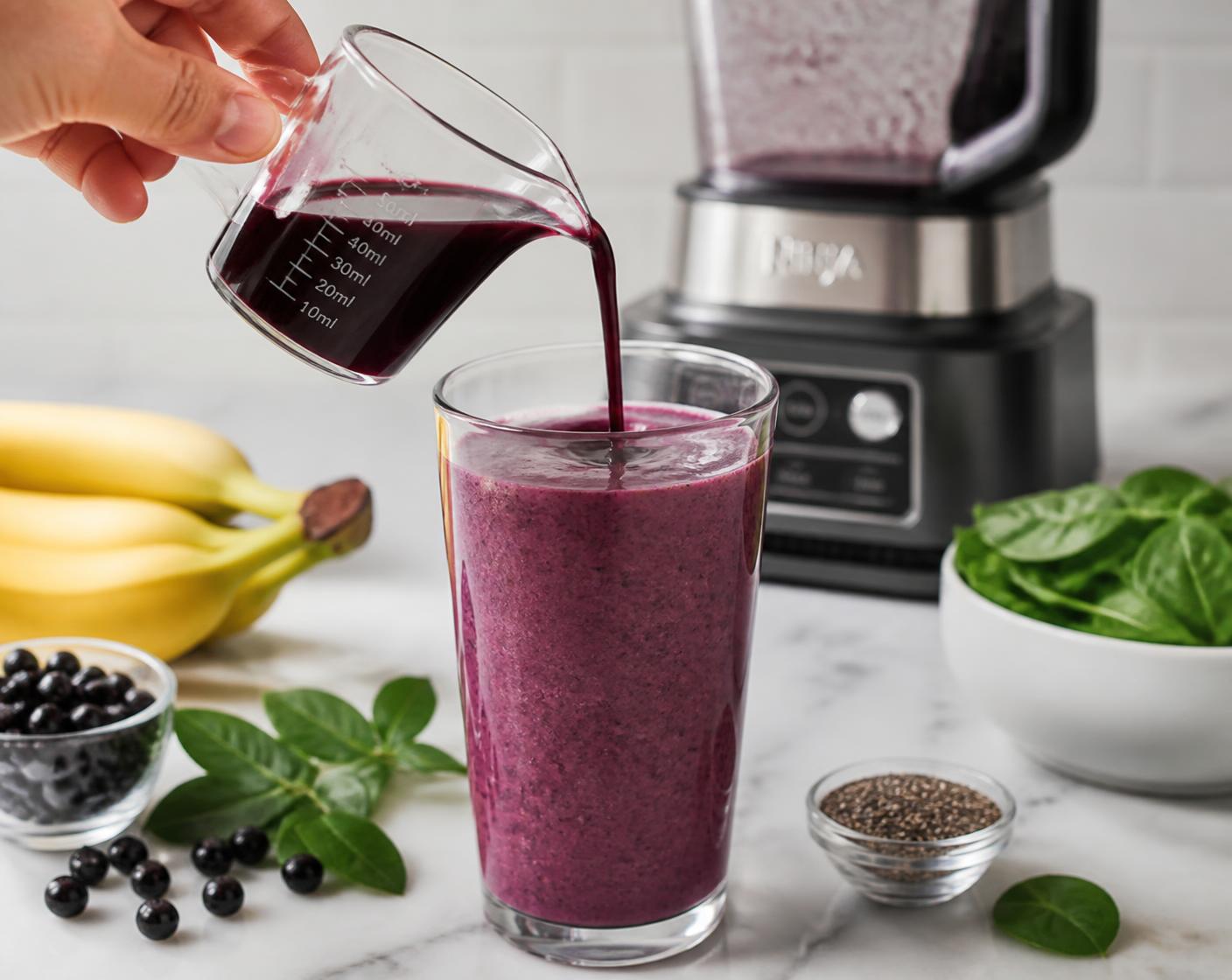 A measured 100 ml serving of Aronia juice on a stone counter