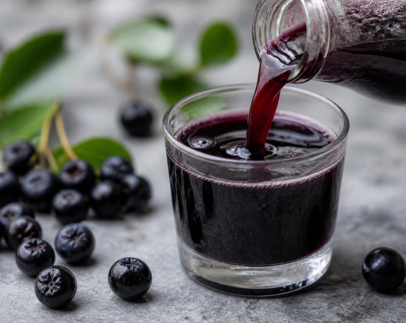 Unsweetened Aronia juice being poured into a tasting glass